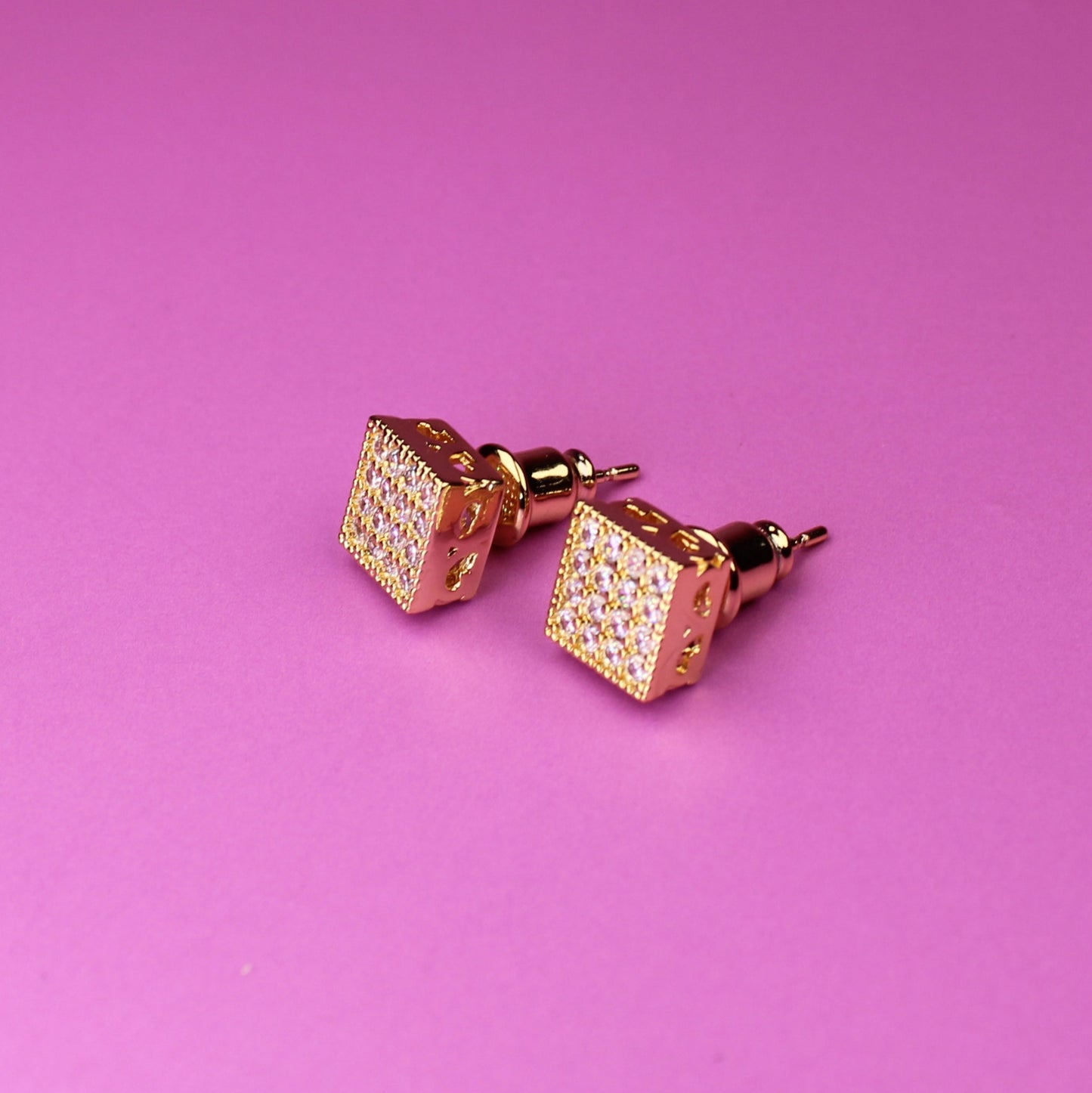 Rose gold cufflinks on a pink background