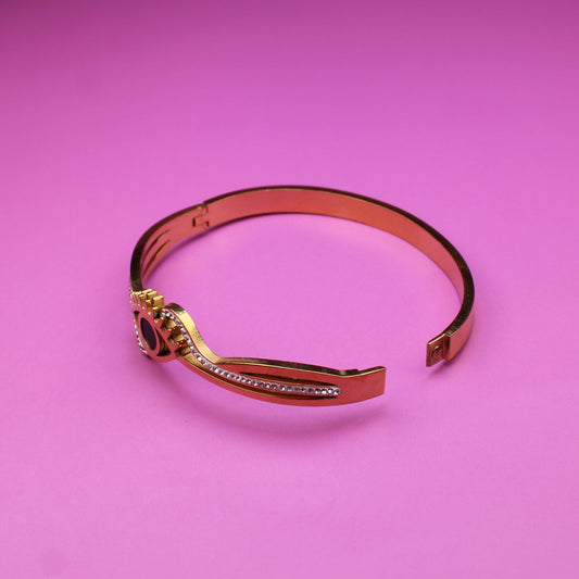 Gold bracelet on a pink background