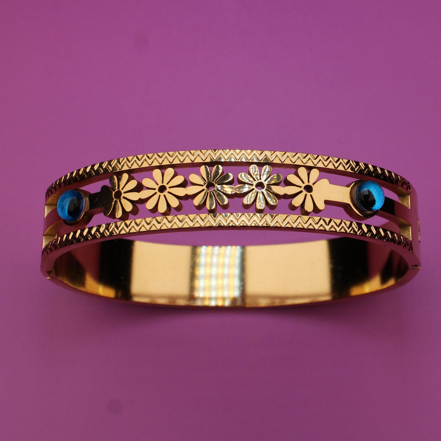 Decorative ring with floral patterns and gemstones on a purple background