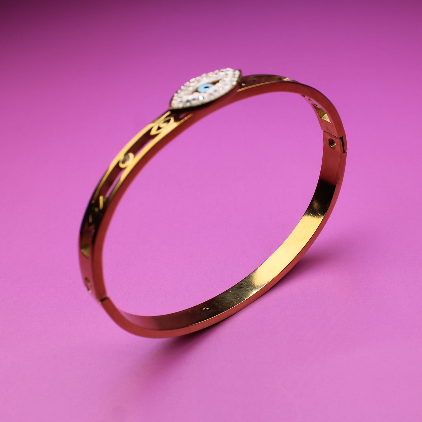 Gold bracelet with a diamond on a pink background