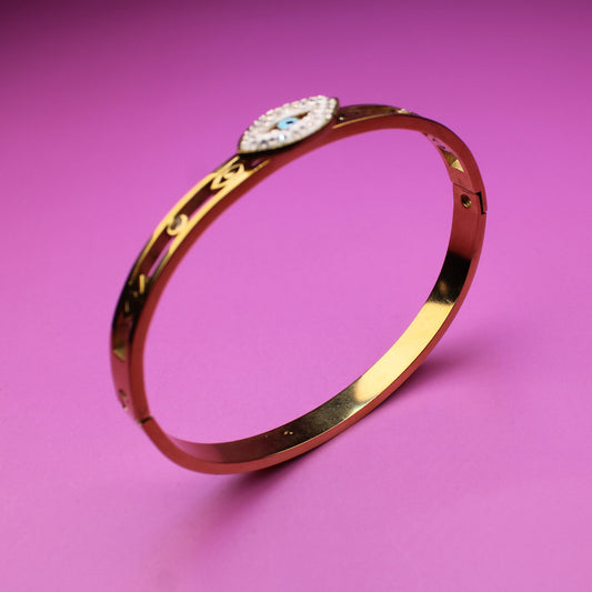 Gold bracelet with a diamond on a pink background