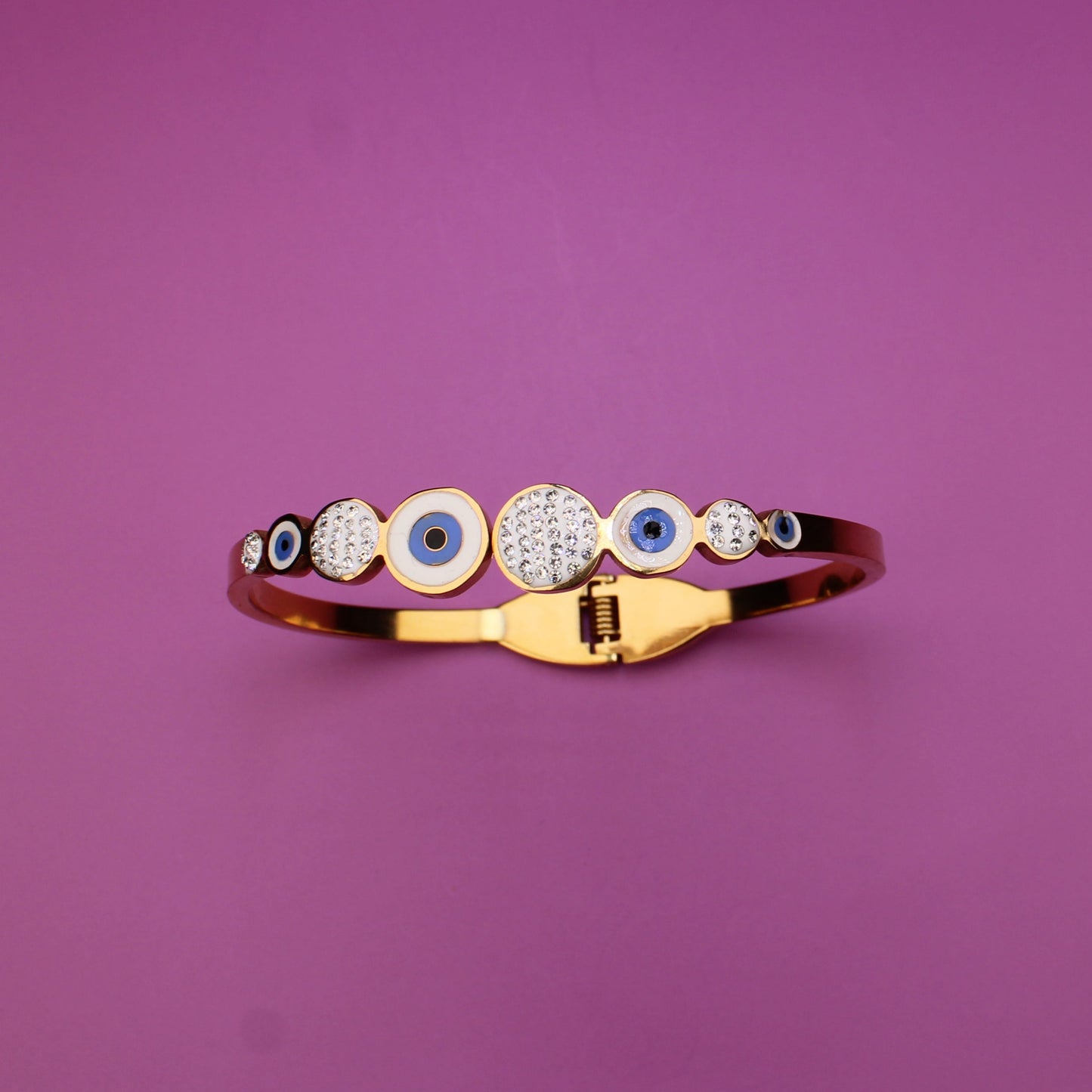 Gold ring with embedded stones on a purple background