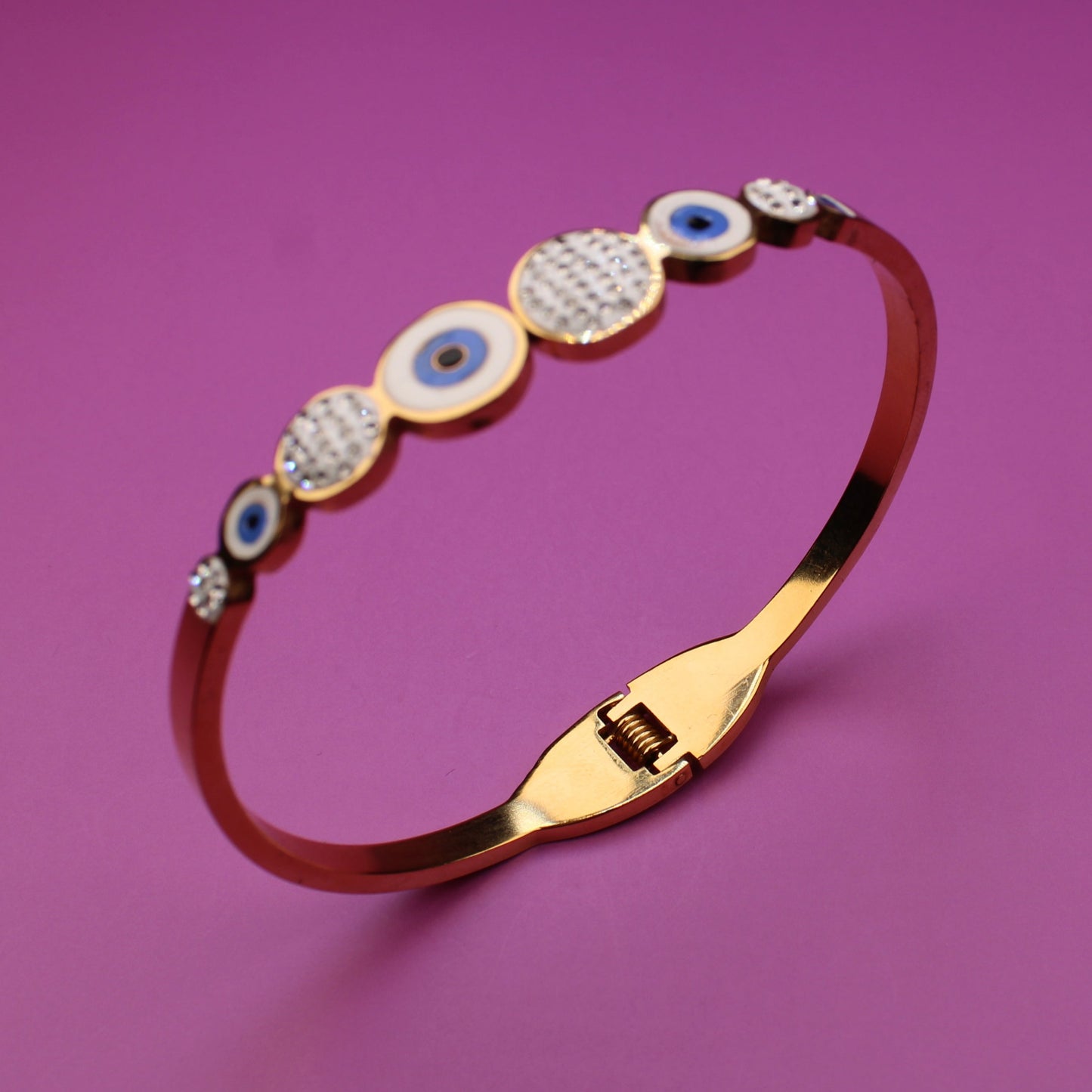Gold bracelet with gemstones on a purple background