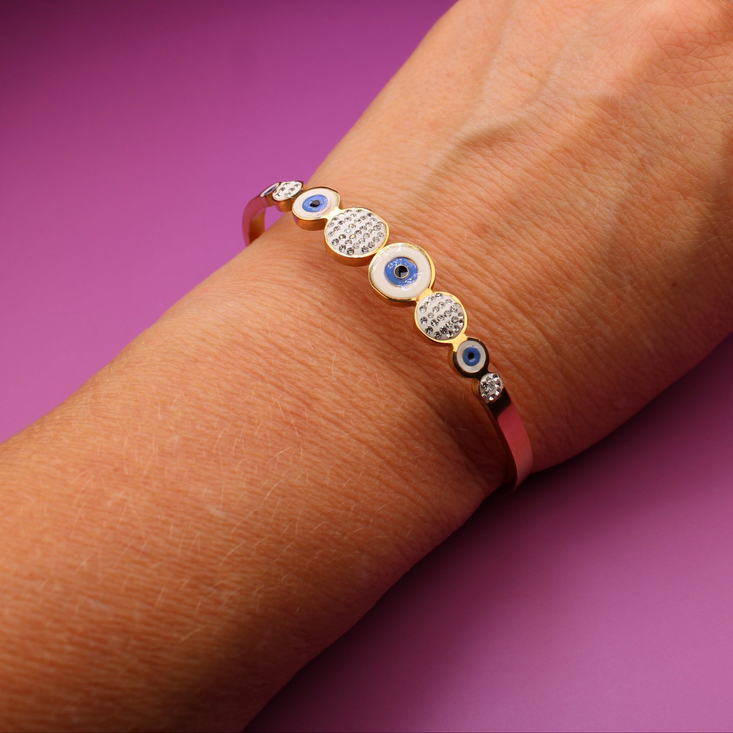 Hand wearing a bracelet with purple background