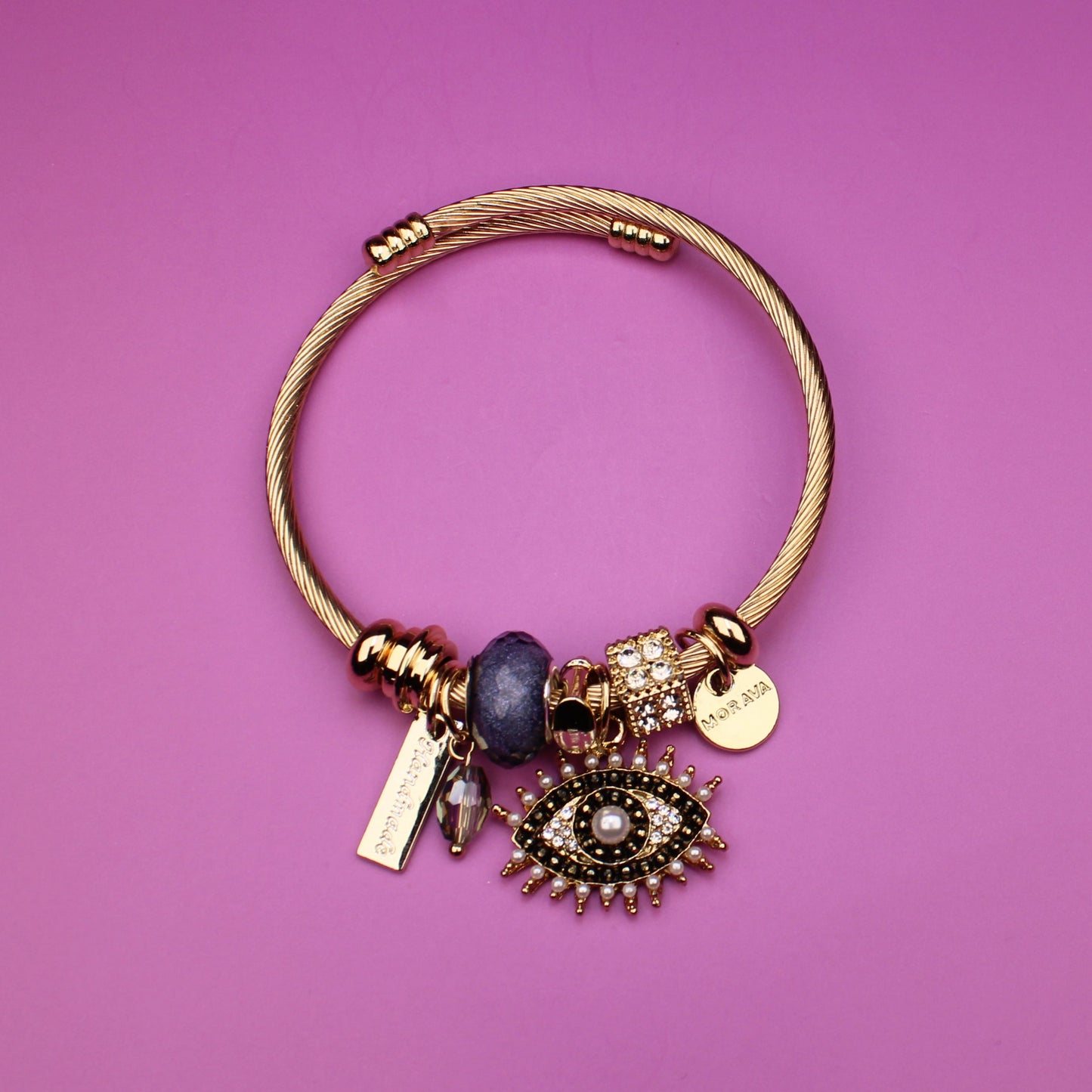 Gold bracelet with charms on a purple background