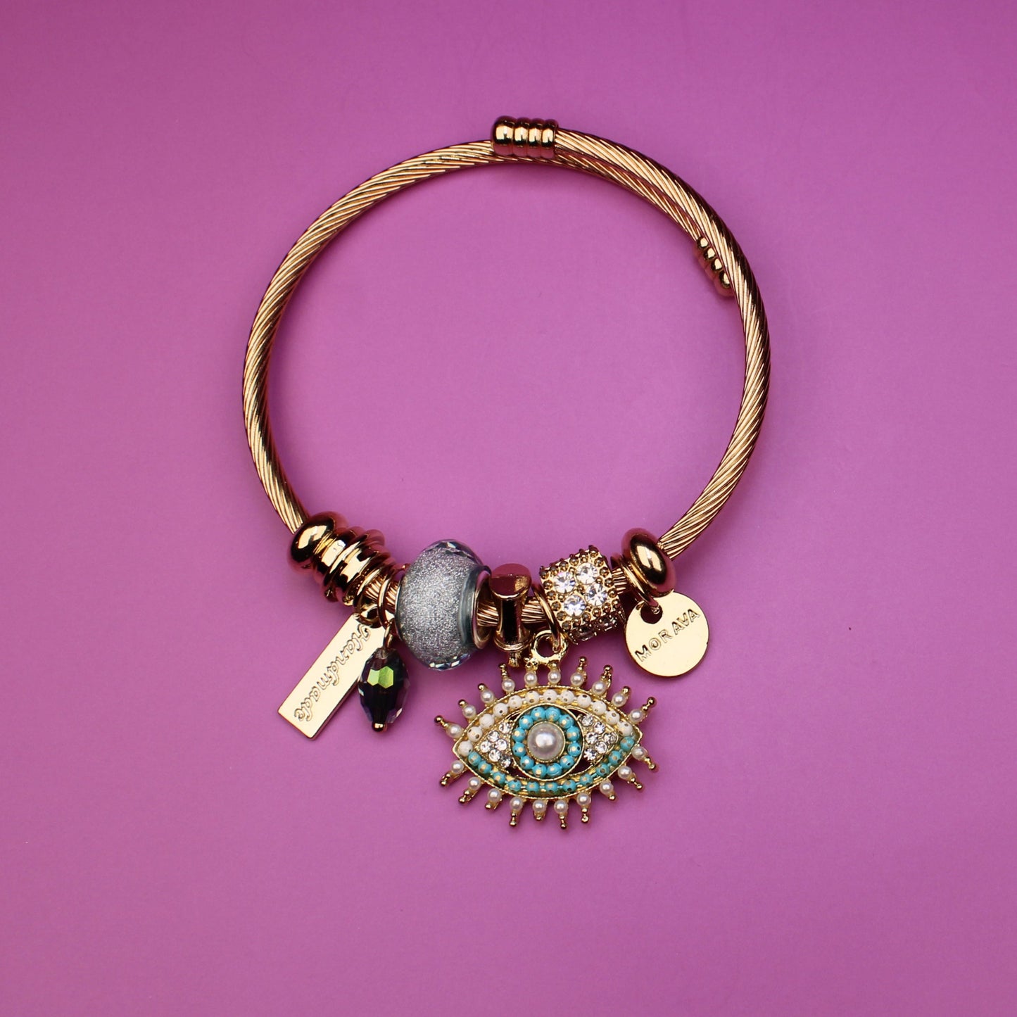 Gold bracelet with charms on a purple background