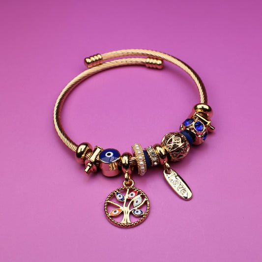 Gold bracelet with charms on a pink background