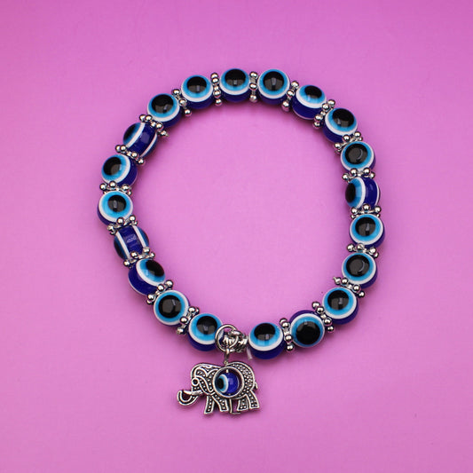 Bracelet with blue beads and elephant charm on a pink background