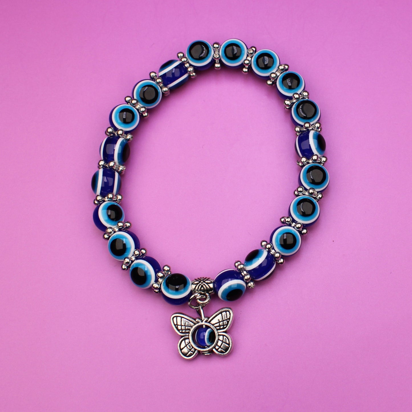 Bracelet with blue and green beads on a pink background