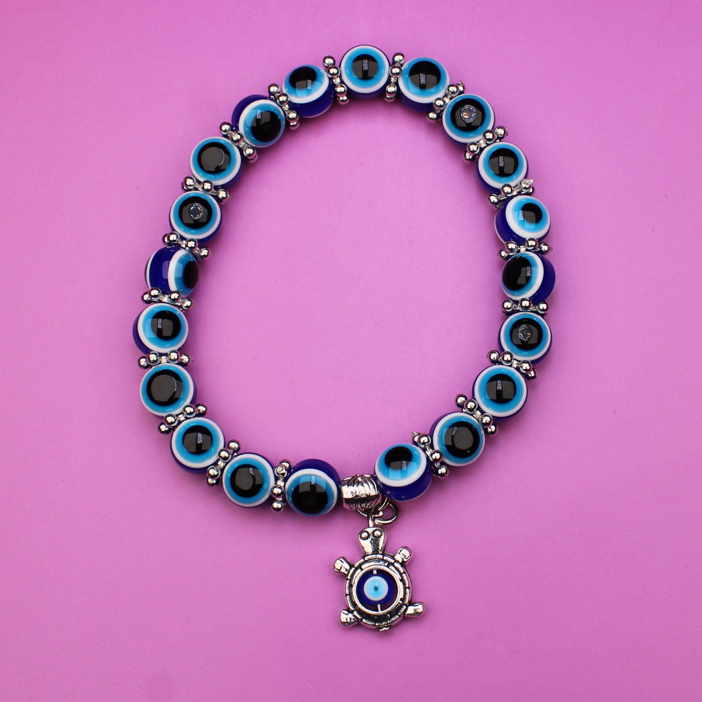 Bracelet with blue and silver charms on a pink background