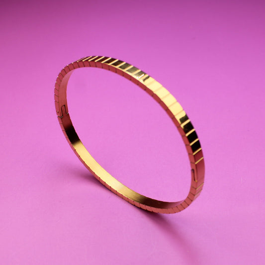 Gold bracelet on a pink background