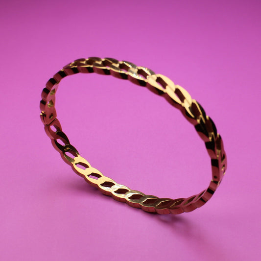 Gold bracelet on a pink background
