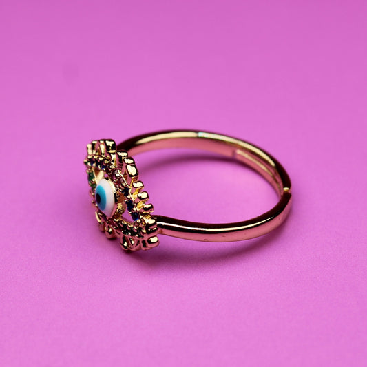 Gold ring with a gemstone on a pink background