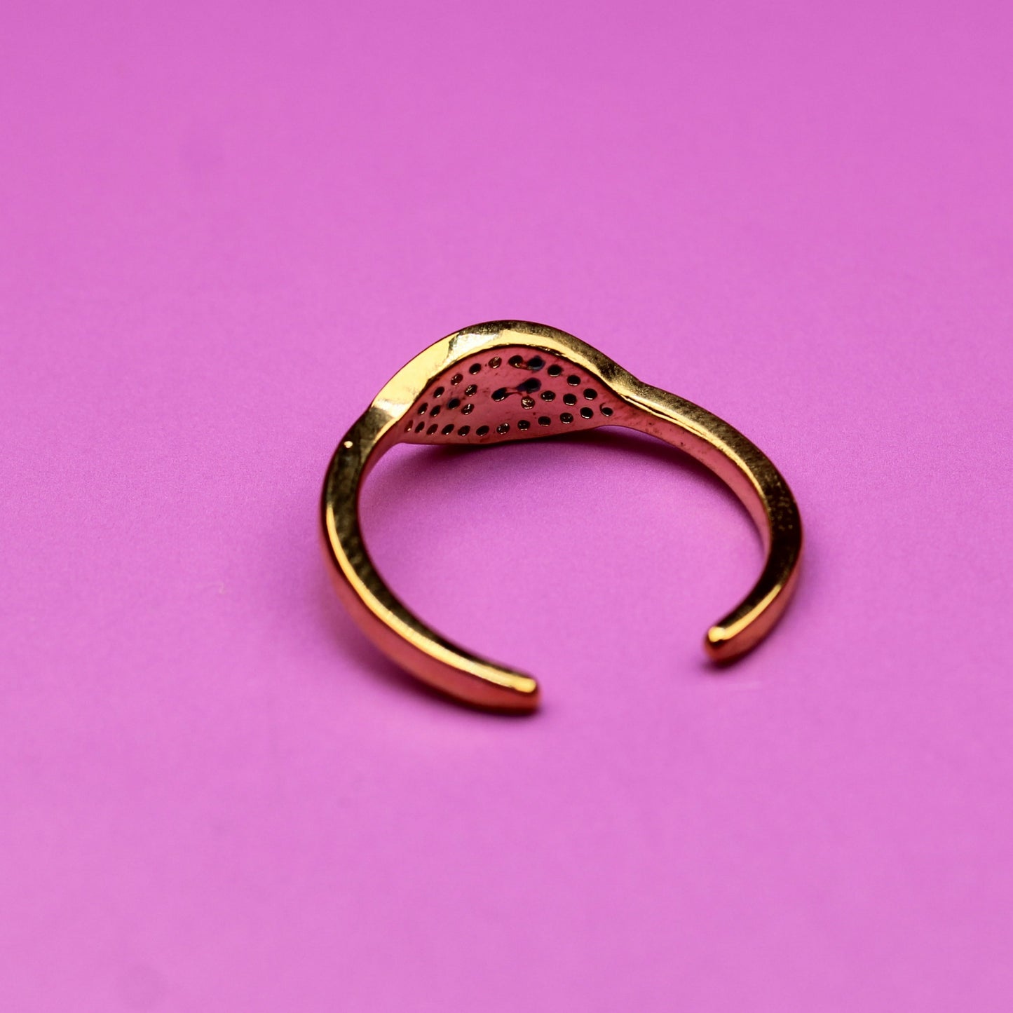 Gold open ring on a pink background