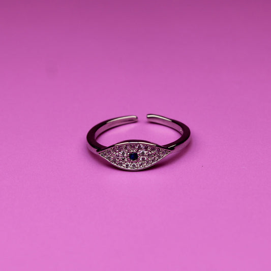 Silver ring with a central gemstone on a pink background