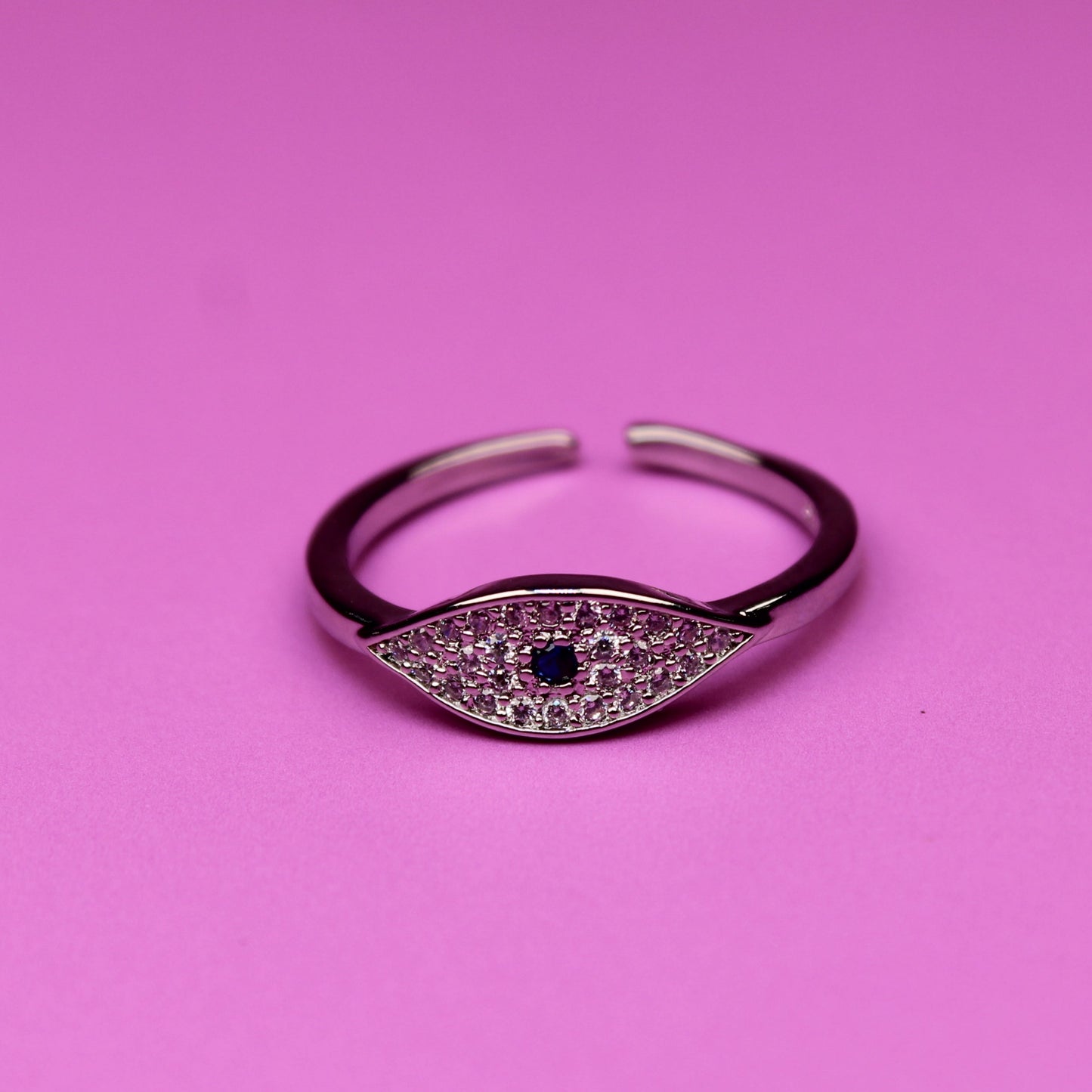 Silver ring with a black gemstone on a pink background