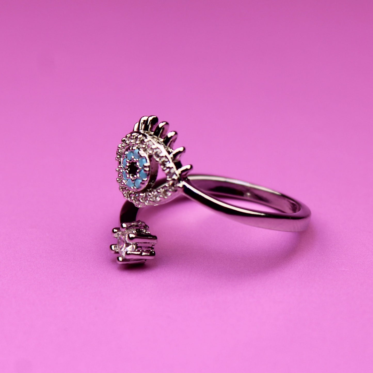 Silver ring with a blue gemstone on a pink background