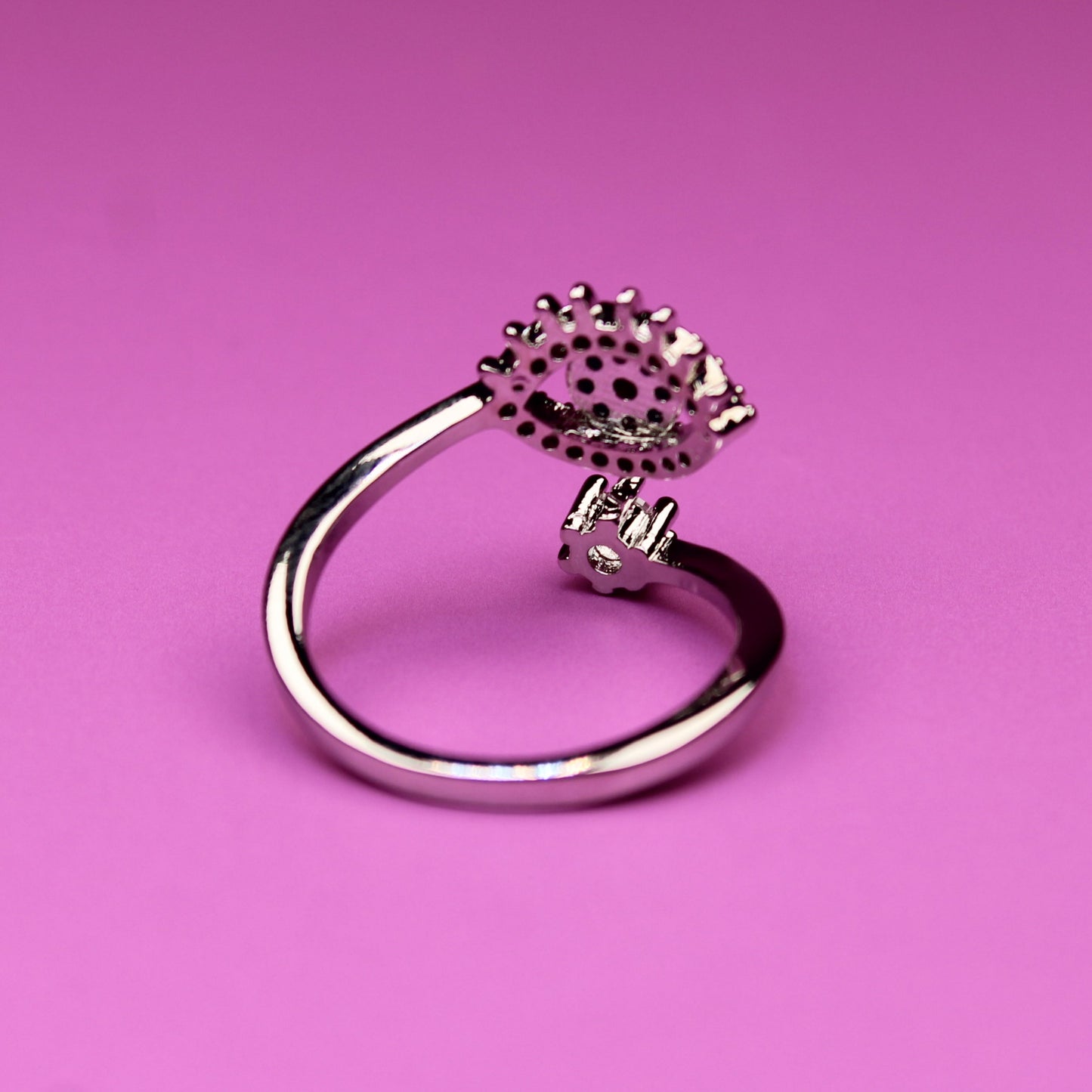 Silver ring with a unique design on a pink background