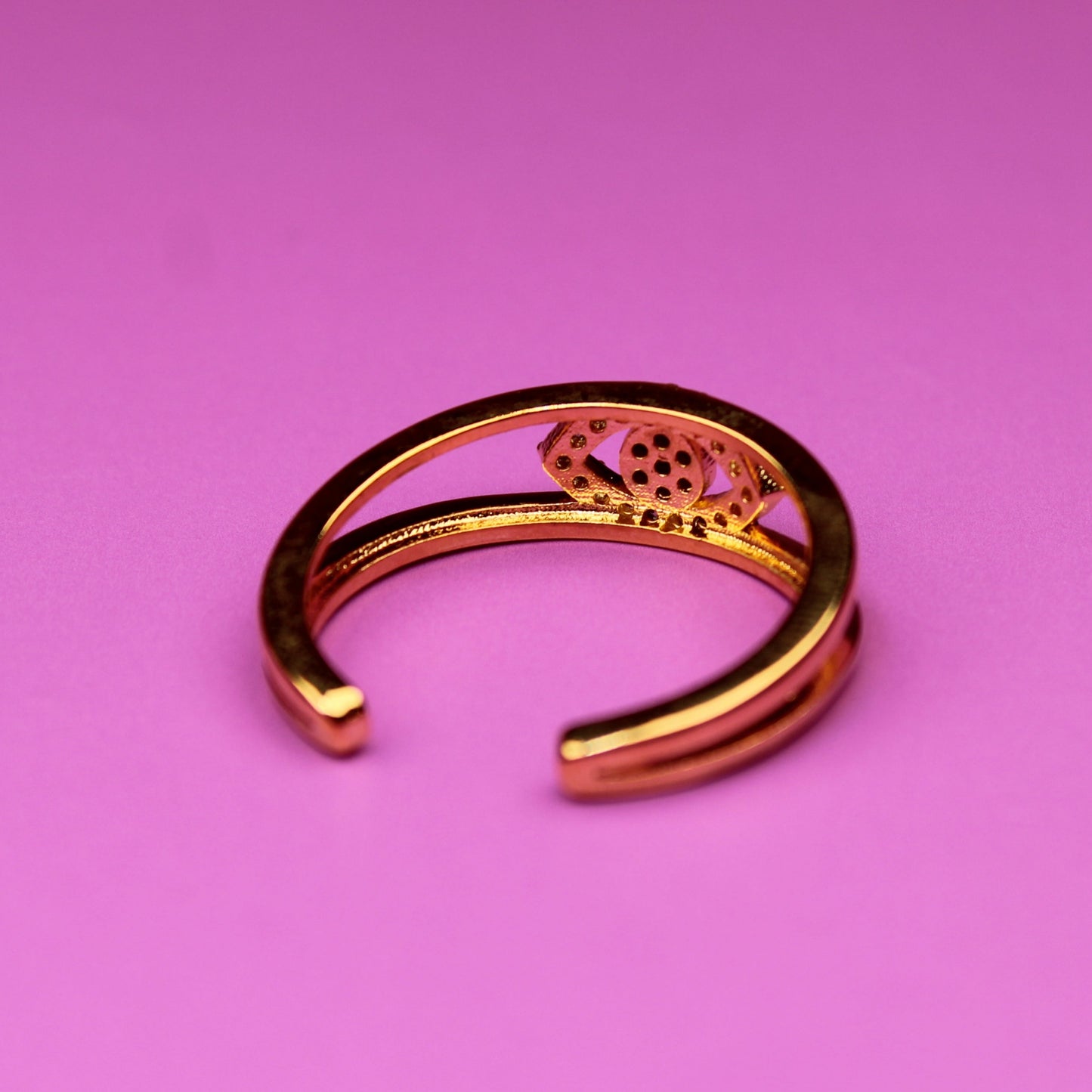 Gold bracelet on a pink background
