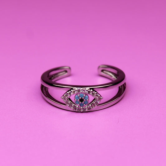Silver bracelet with a blue gem on a pink background