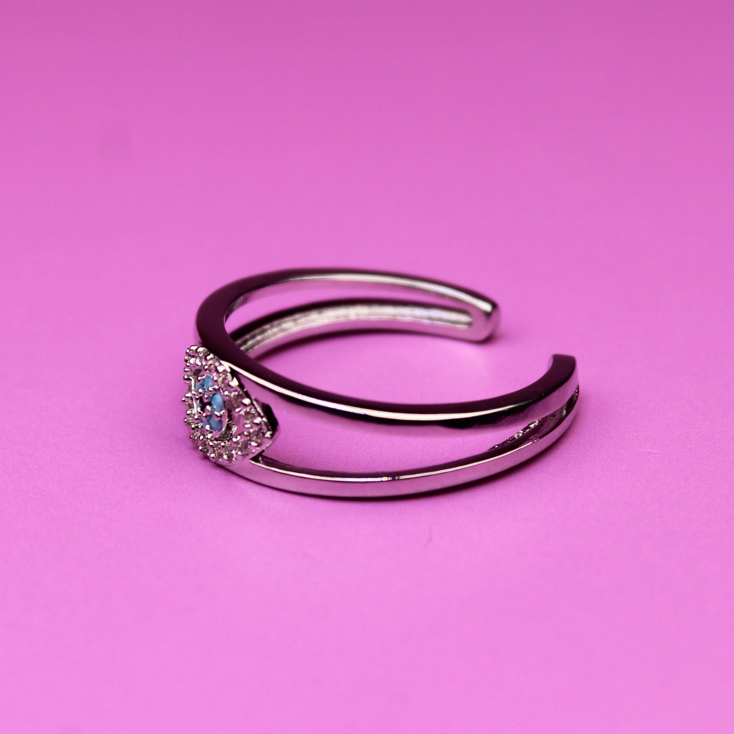 Silver ring with a gemstone on a pink background