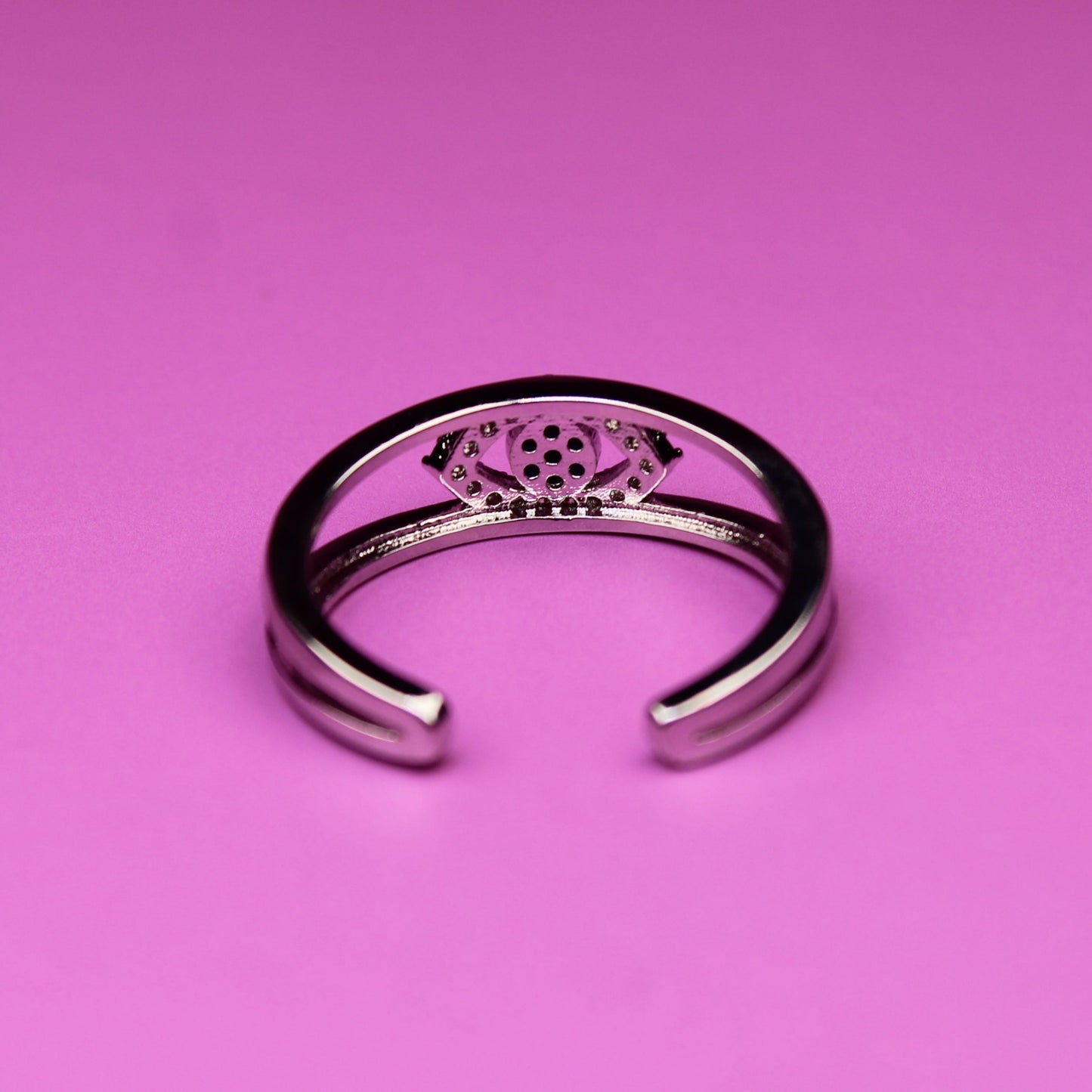 Silver ring with a pink gemstone on a pink background