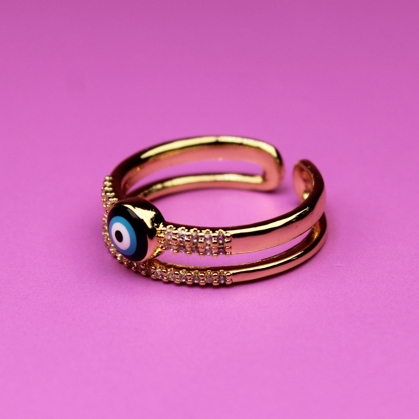 Gold ring with a blue gemstone on a pink background