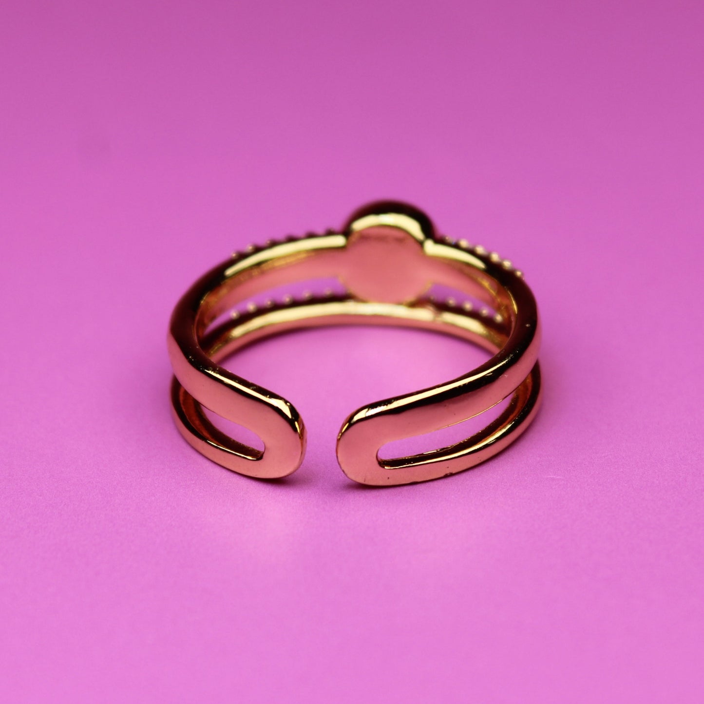 Rose gold ring on a pink background