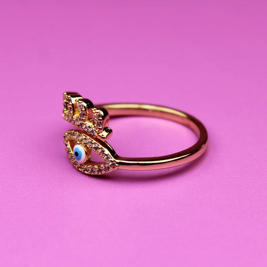 Gold ring with gemstones on a pink background