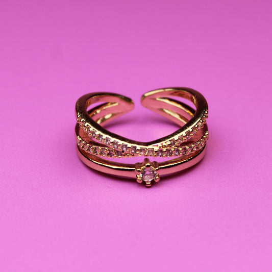 Rose gold ring with gemstones on a pink background