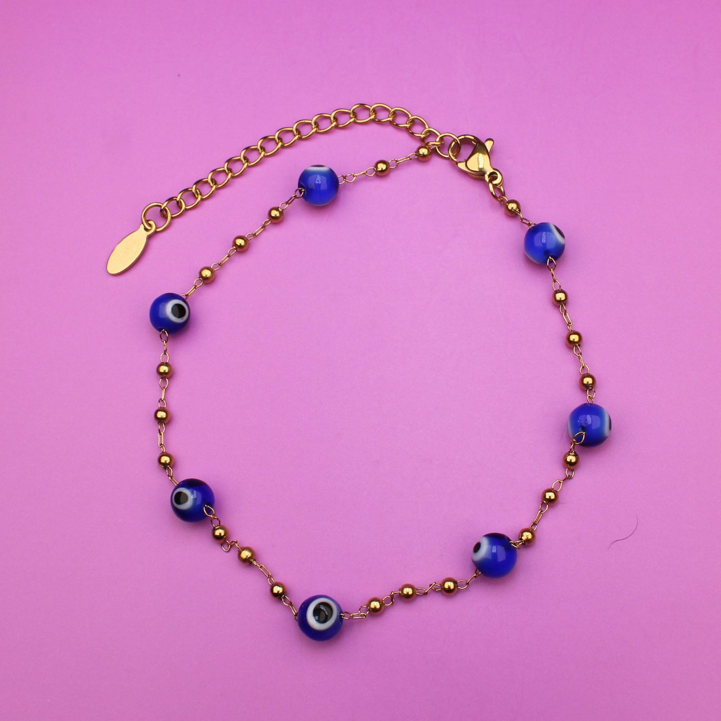 Bracelet with blue beads on a pink background