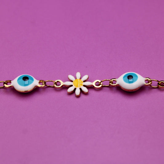 Bracelet with eye and flower charms on a purple background