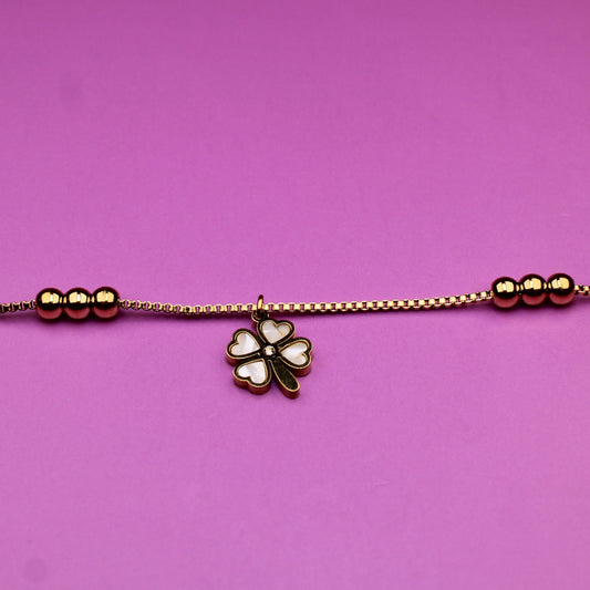 Bracelet with a clover charm on a pink background