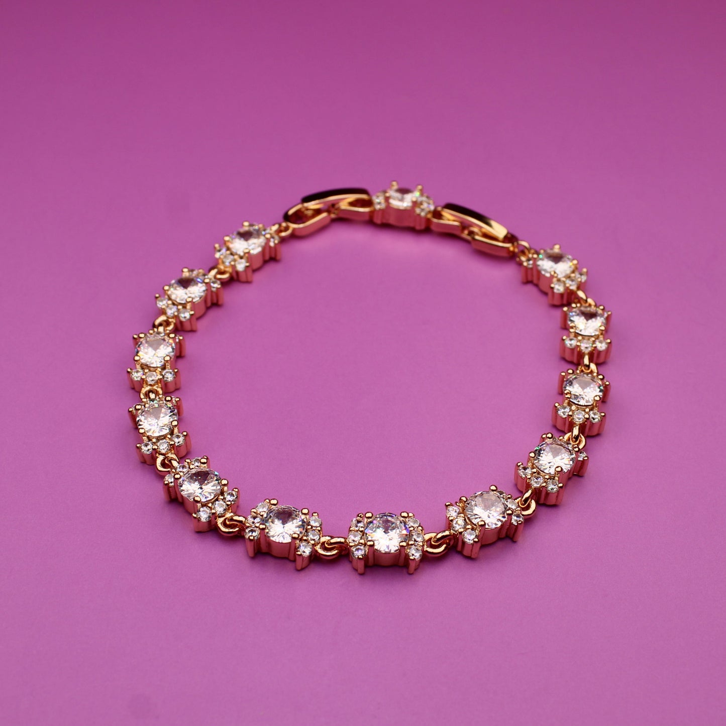 Gold bracelet with crystals on a purple background