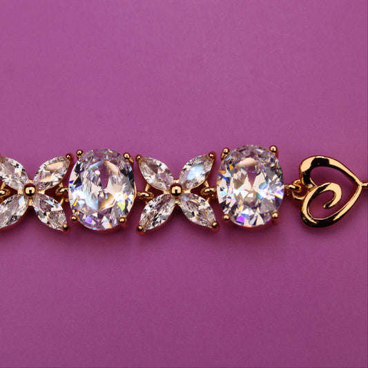Gold bracelet with clear gemstones on a purple background