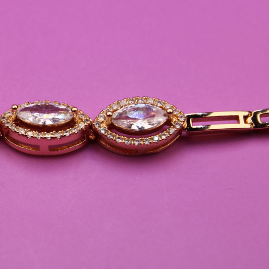 Rose gold bracelet with gemstones on a pink background