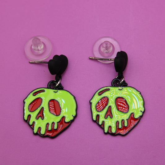 Heart-shaped earrings with green skull design on a pink background
