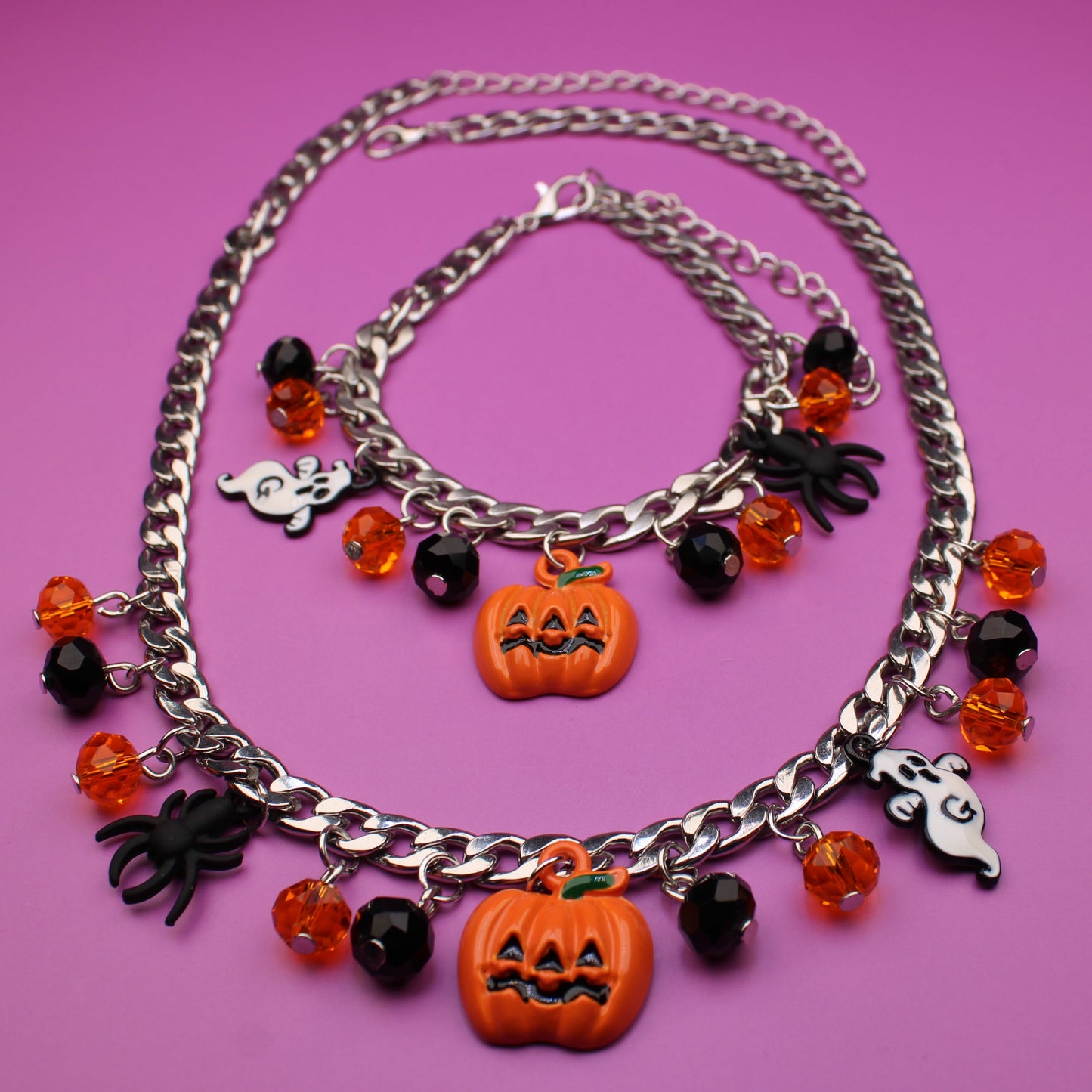 Necklace with Halloween-themed charms on a pink background