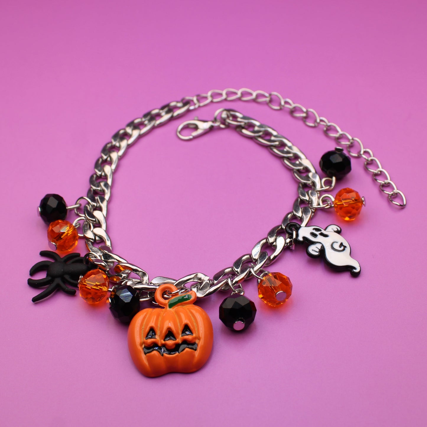 Bracelet with Halloween-themed charms on a pink background