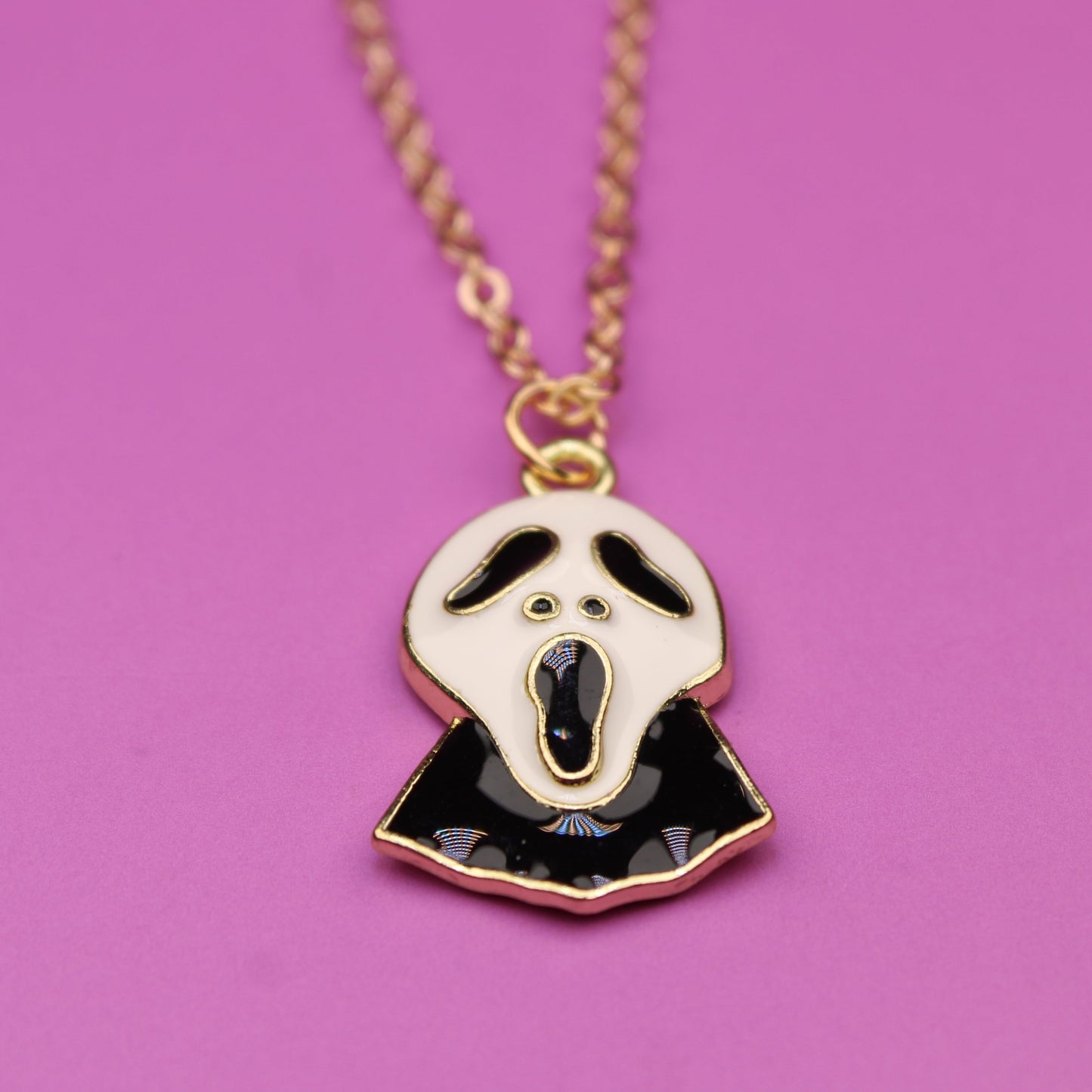 Necklace with a ghost pendant on a pink background