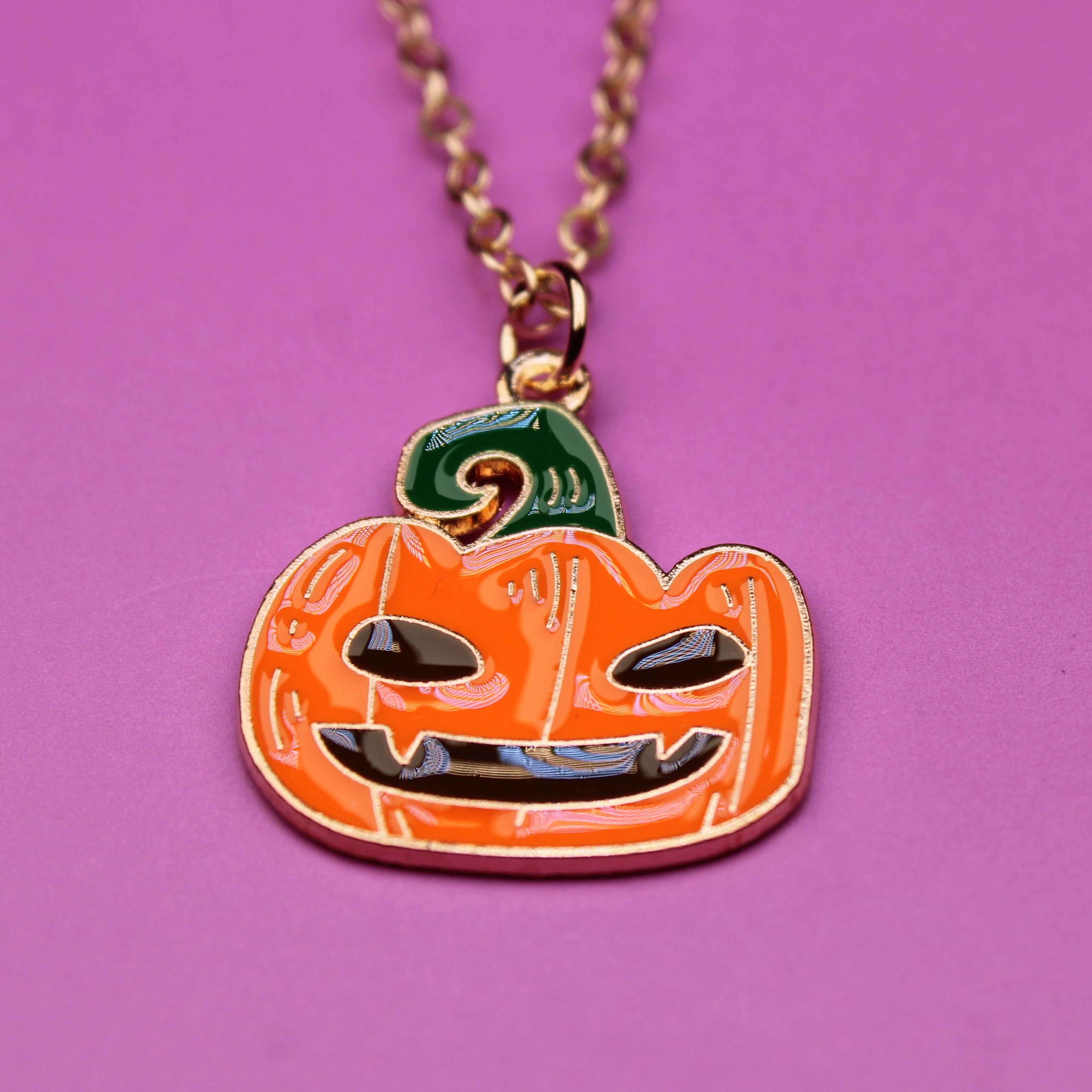 Pumpkin-shaped pendant necklace on a purple background