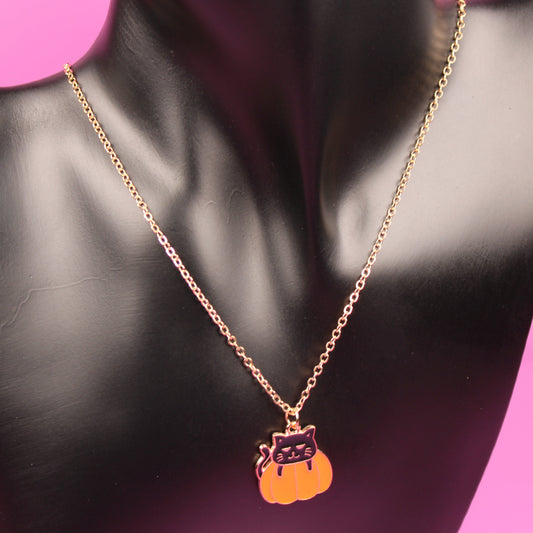 Necklace with a pendant on a black mannequin bust against a pink background