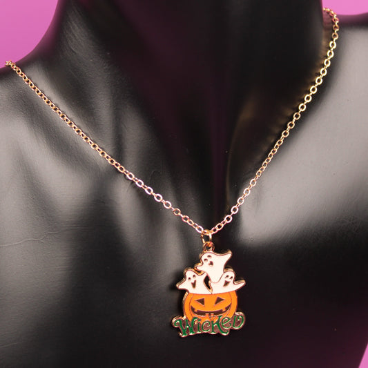 Pumpkin-shaped pendant necklace on a black mannequin bust with a pink background