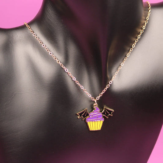 Necklace with a cupcake pendant on a mannequin bust against a pink background