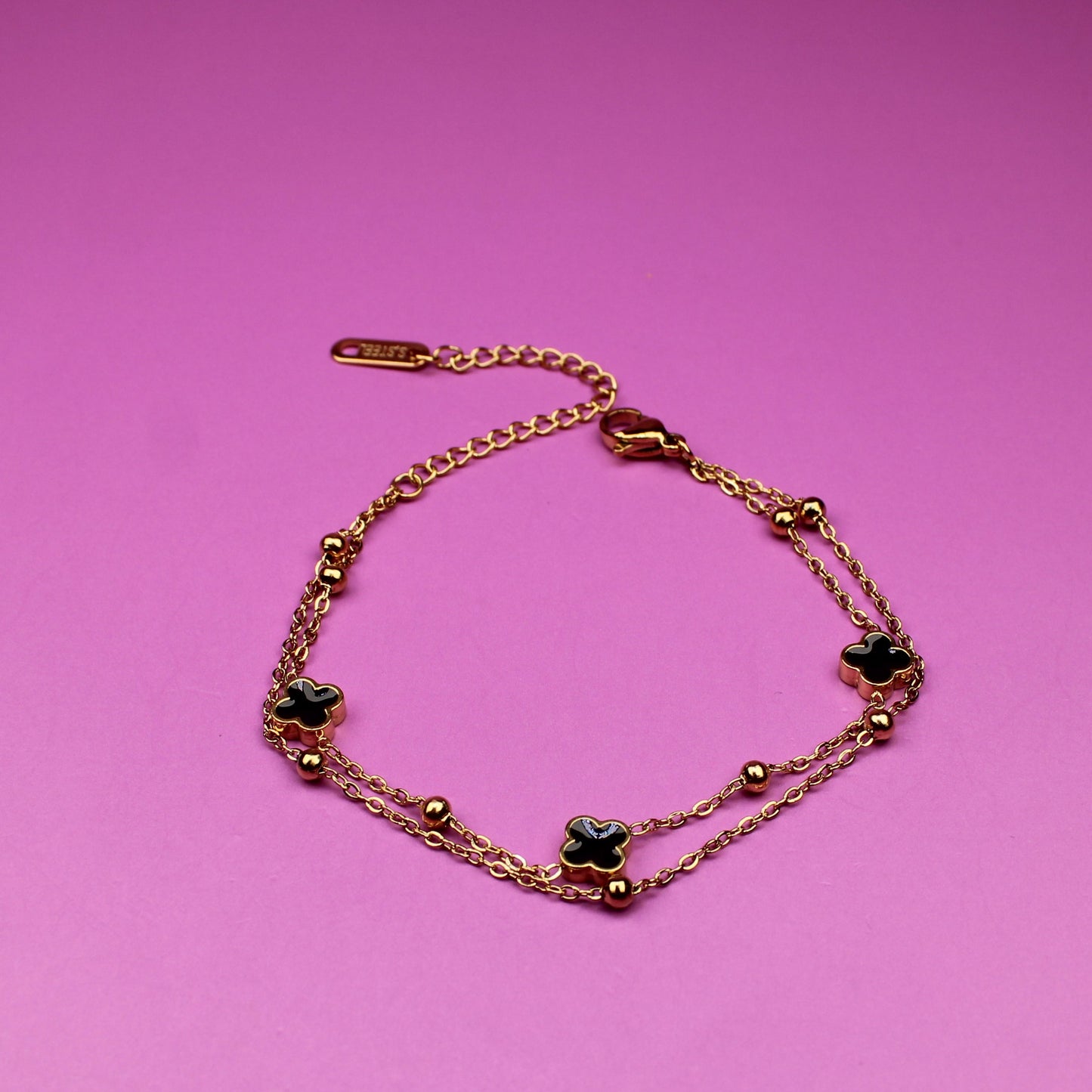 Bracelet with green stones on a pink background