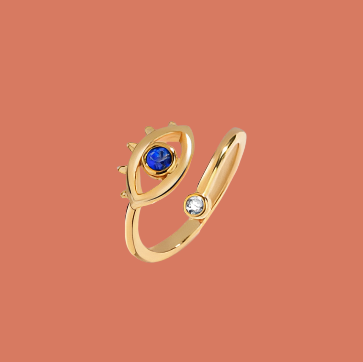 Gold ring with blue gemstone and diamond on a pink background