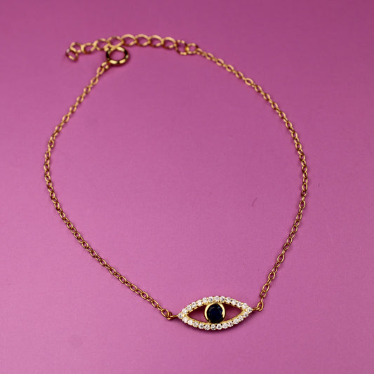 Gold bracelet with an eye-shaped charm on a pink background