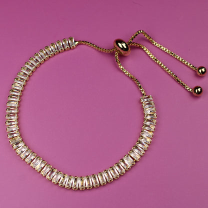Gold beaded bracelet on a pink background