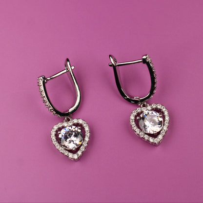 Heart-shaped earrings on a pink background