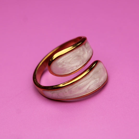 Two-layered ring with gold band and pink stone on a pink background